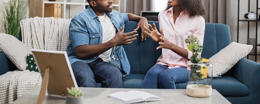 arguing - ADHD-Focused Couples Therapy in NYC - therapy for couples with ADHD - couples therapy - 10018 - 10010 - 10003 Couple arguing on their couch representing a couple who would benefit from ADHD-Focused Couples Therapy in NYC.